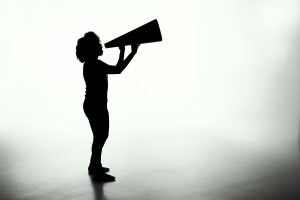 Grayscale image of person with megaphone.